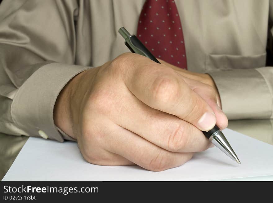 Hand with pen writing on the page and reflection