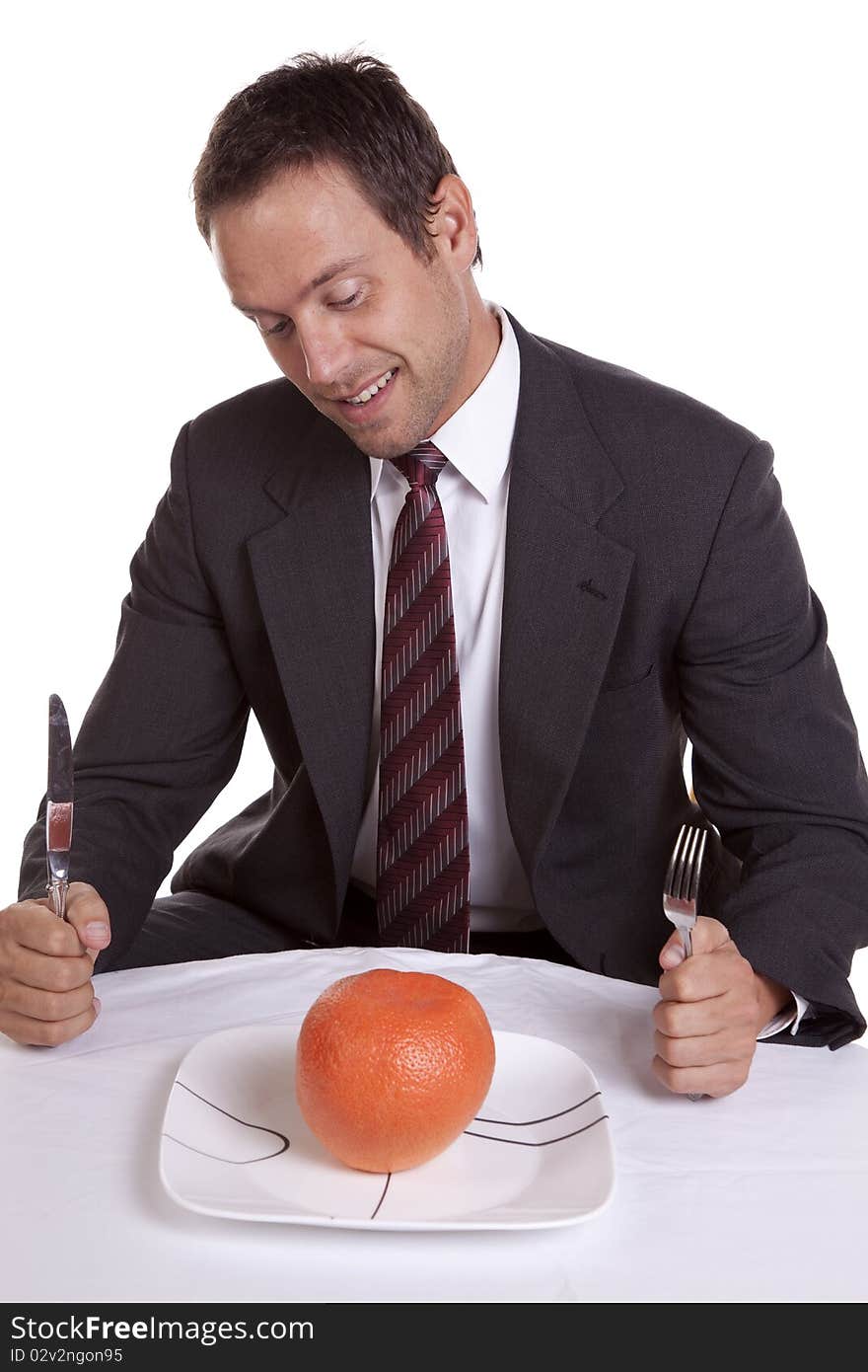 A man trying to be healthy and getting ready to dig into a orange on his plate. A man trying to be healthy and getting ready to dig into a orange on his plate.