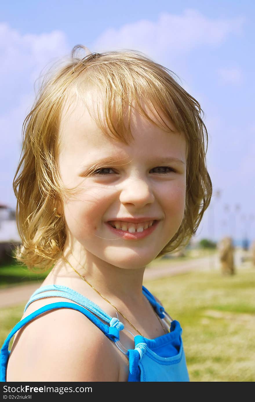 Portrait of a happy little girl on the green grass background. Portrait of a happy little girl on the green grass background.