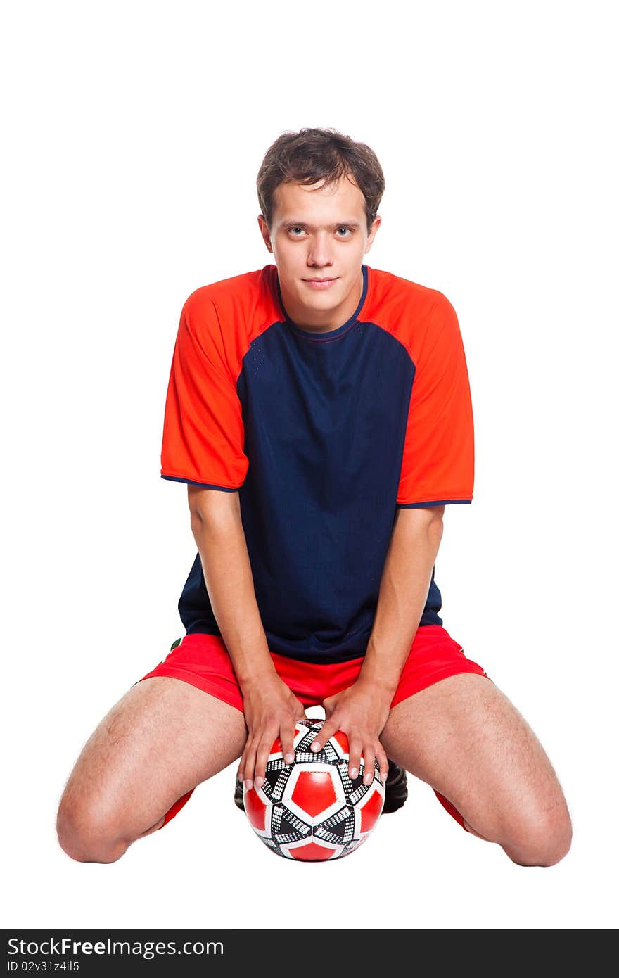 Football player in red clothes sitting in studio