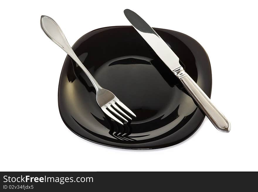 Black high-gloss plate with stainless fork and knife. Black high-gloss plate with stainless fork and knife