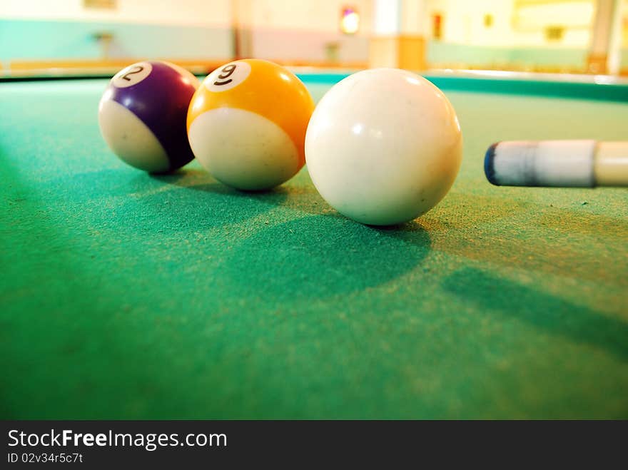 Closeup of a white Billiard Ball on green layout table with a stick ready to shot. Closeup of a white Billiard Ball on green layout table with a stick ready to shot