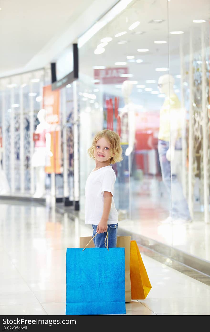 Little girl with bags in the store. Little girl with bags in the store