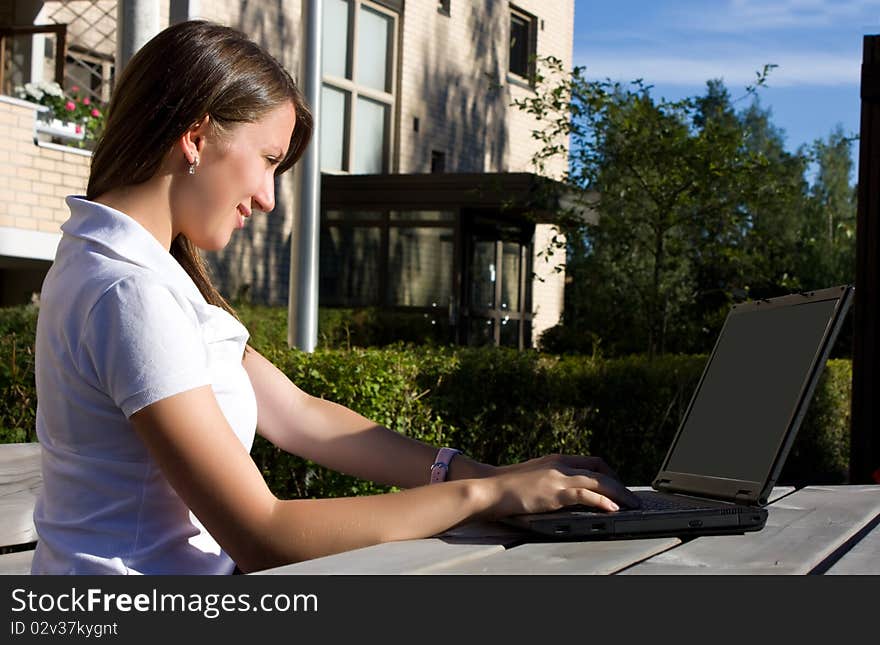 Woman With Laptop Sitting On The Bench In A Park