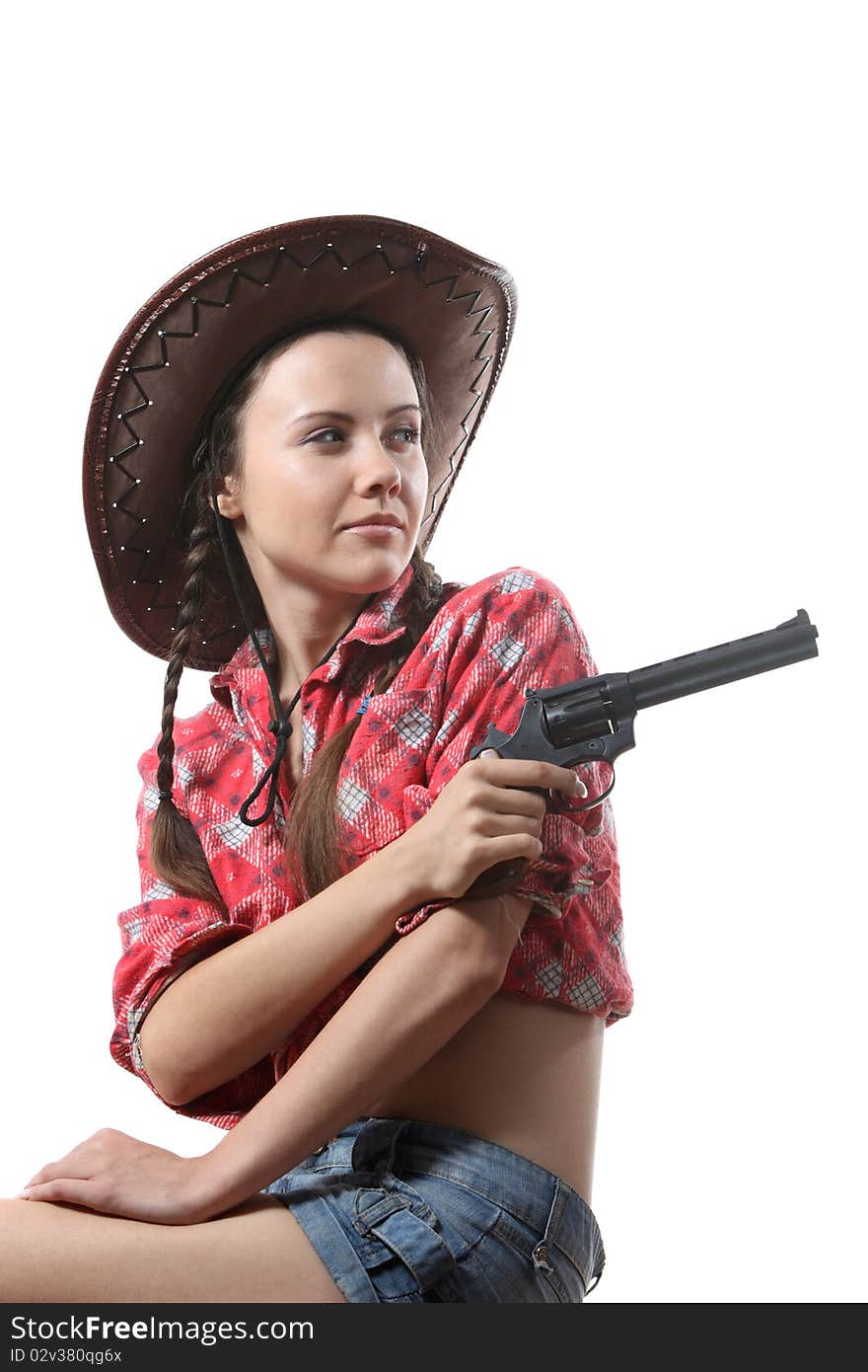 Pretty young girl in the cowboy hat with two pigtails arm with revolver. Pretty young girl in the cowboy hat with two pigtails arm with revolver