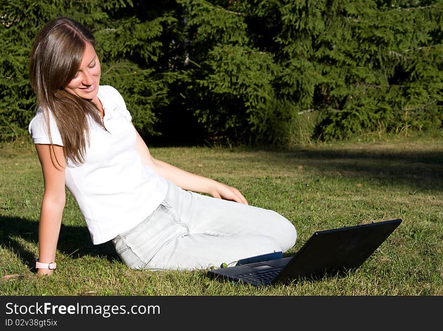 Young businesswoman working on laptop outdoor