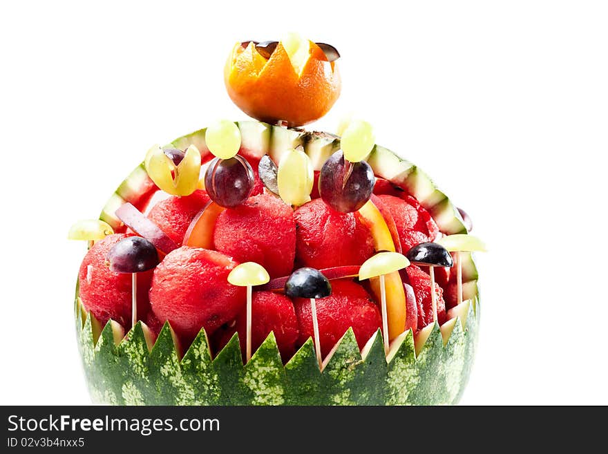 Watermelon rind filled with watermelon balls and grapes on white background. Watermelon rind filled with watermelon balls and grapes on white background.