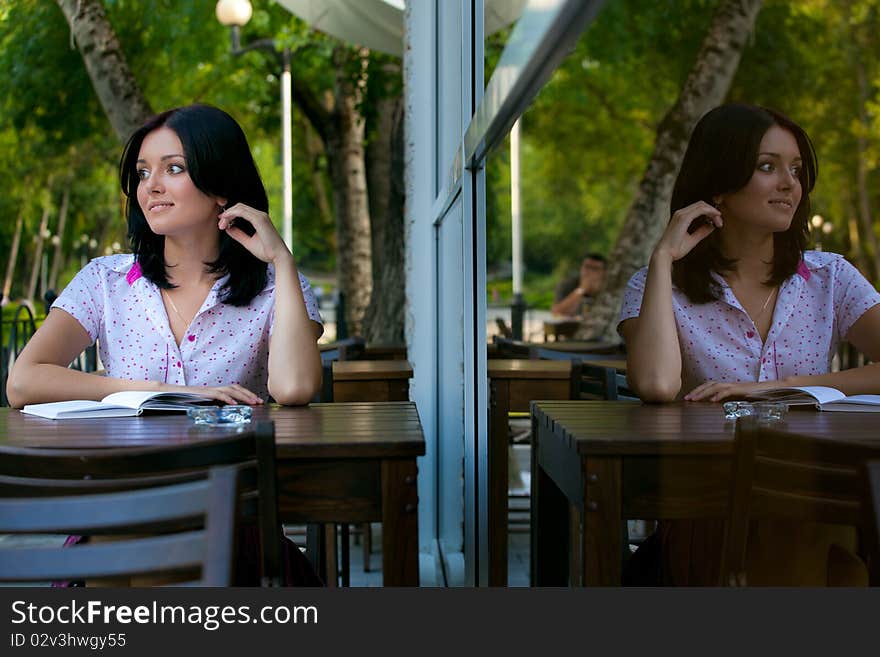 Young beautiful student girl with notepad in the cafe. Young beautiful student girl with notepad in the cafe