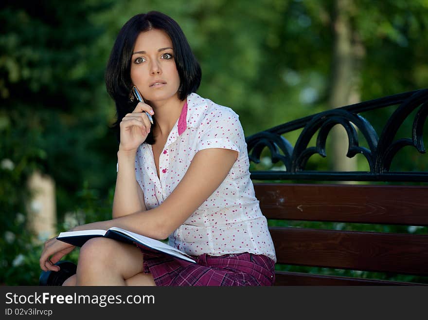 Young beautiful student girl with notepad in the park. Young beautiful student girl with notepad in the park