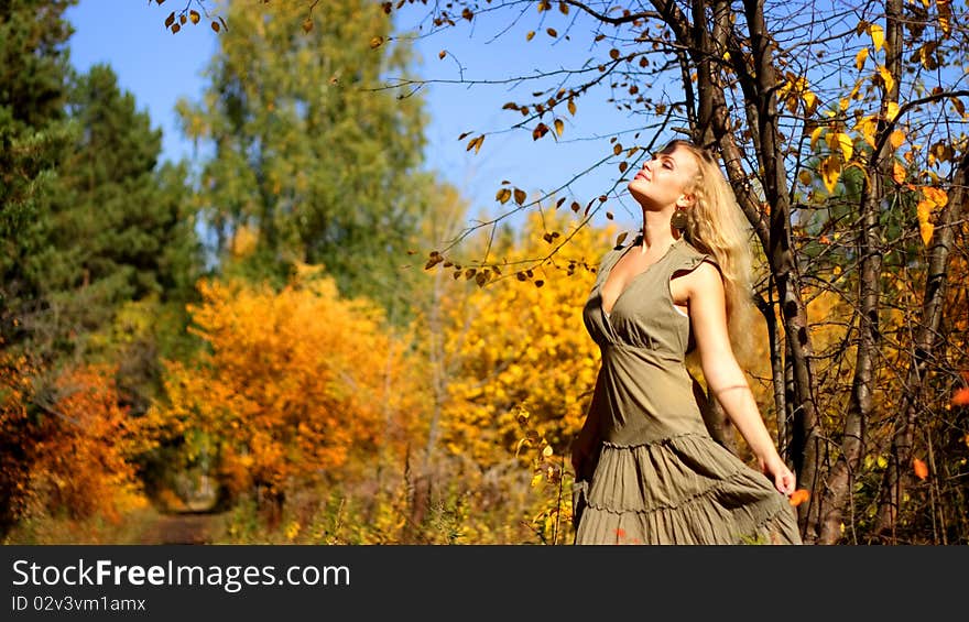 Attractive girl standing beside a tree