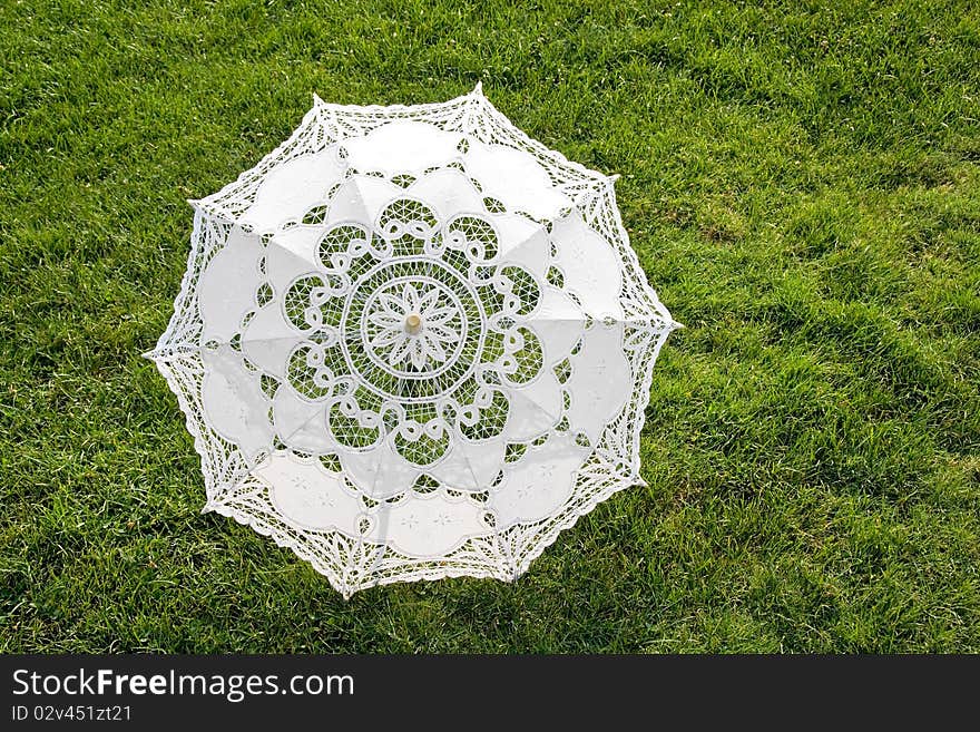 Beautiful white sun umbrella on the green lawn