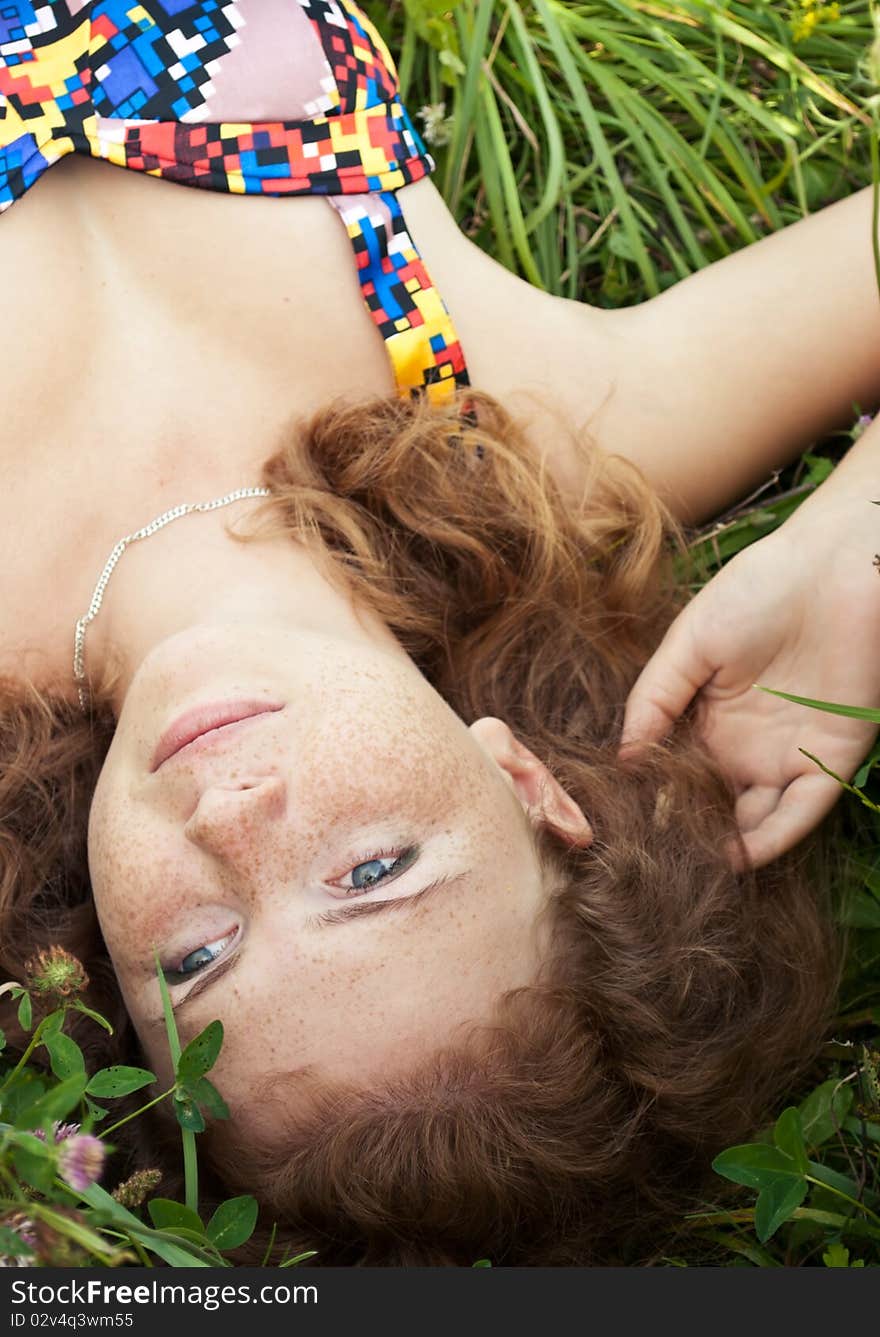 Beautiful Ginger Girl Is Lying In The Green Grass