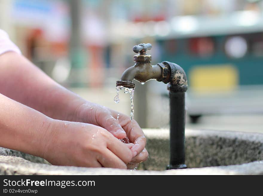 Woman washing hands on a public faucet. Woman washing hands on a public faucet