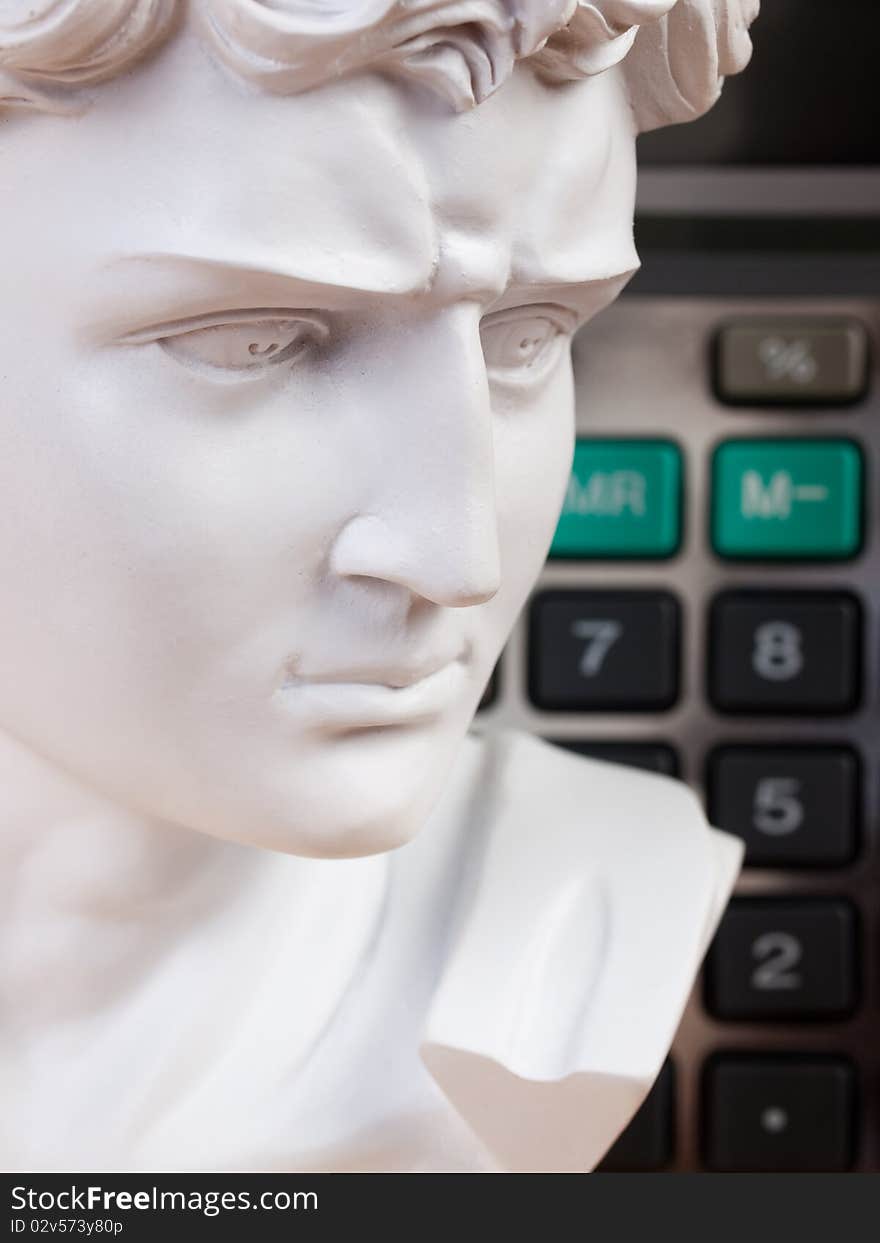 Ancient Roman bust with calculator keys in the background. Ancient Roman bust with calculator keys in the background