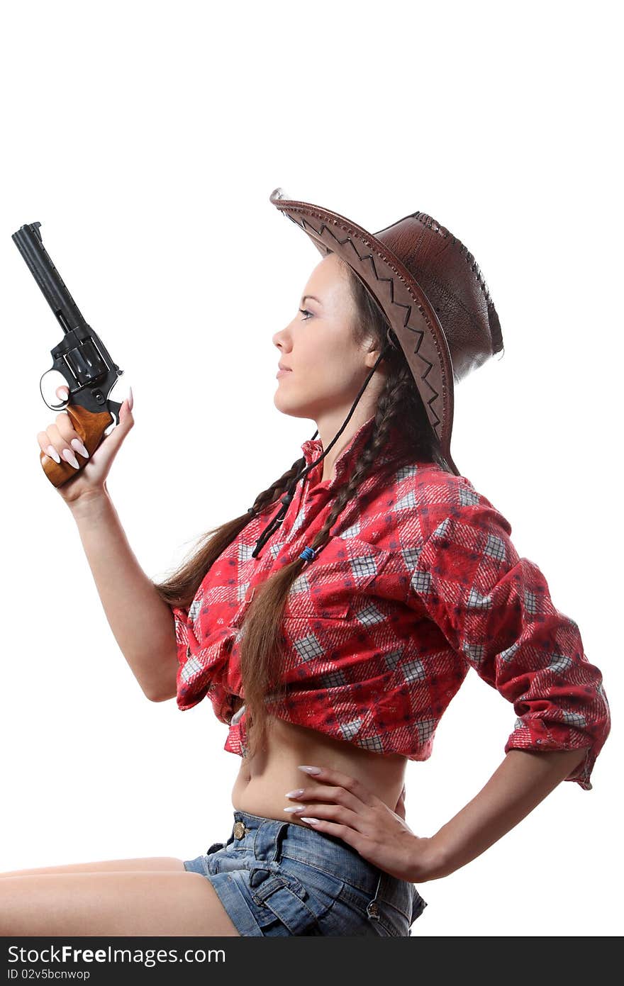 Pretty young girl in the cowboy hat with two pigtails with revolver. Pretty young girl in the cowboy hat with two pigtails with revolver