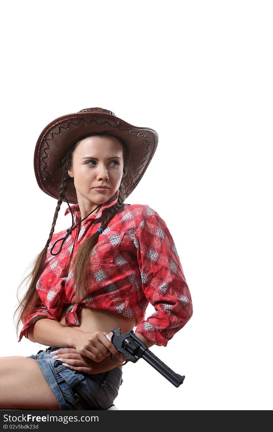 Pretty young girl in the cowboy hat with two pigtails with revolver. Pretty young girl in the cowboy hat with two pigtails with revolver