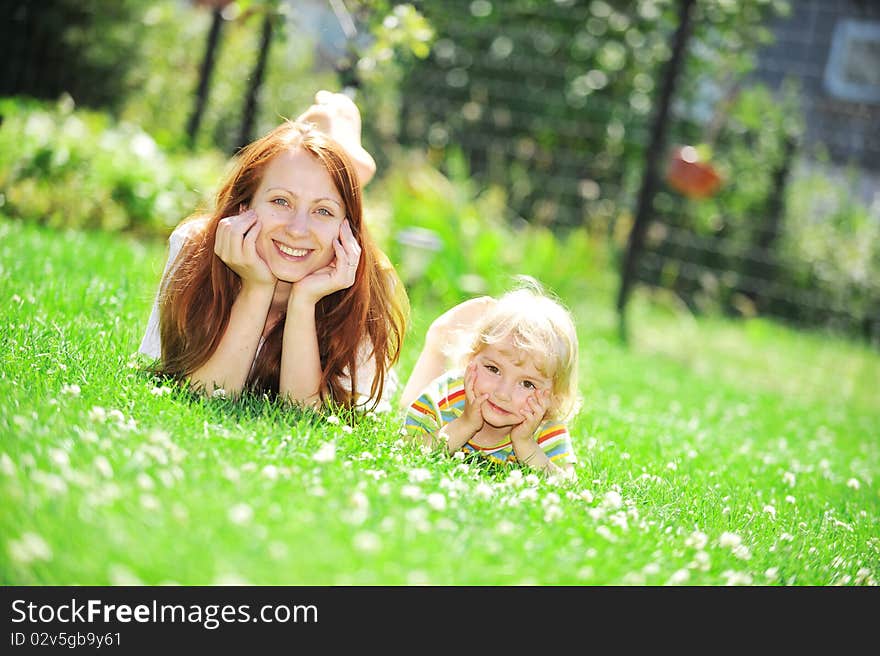 Beautiful young mother with her  daughter lie on grass . summer. Beautiful young mother with her  daughter lie on grass . summer.