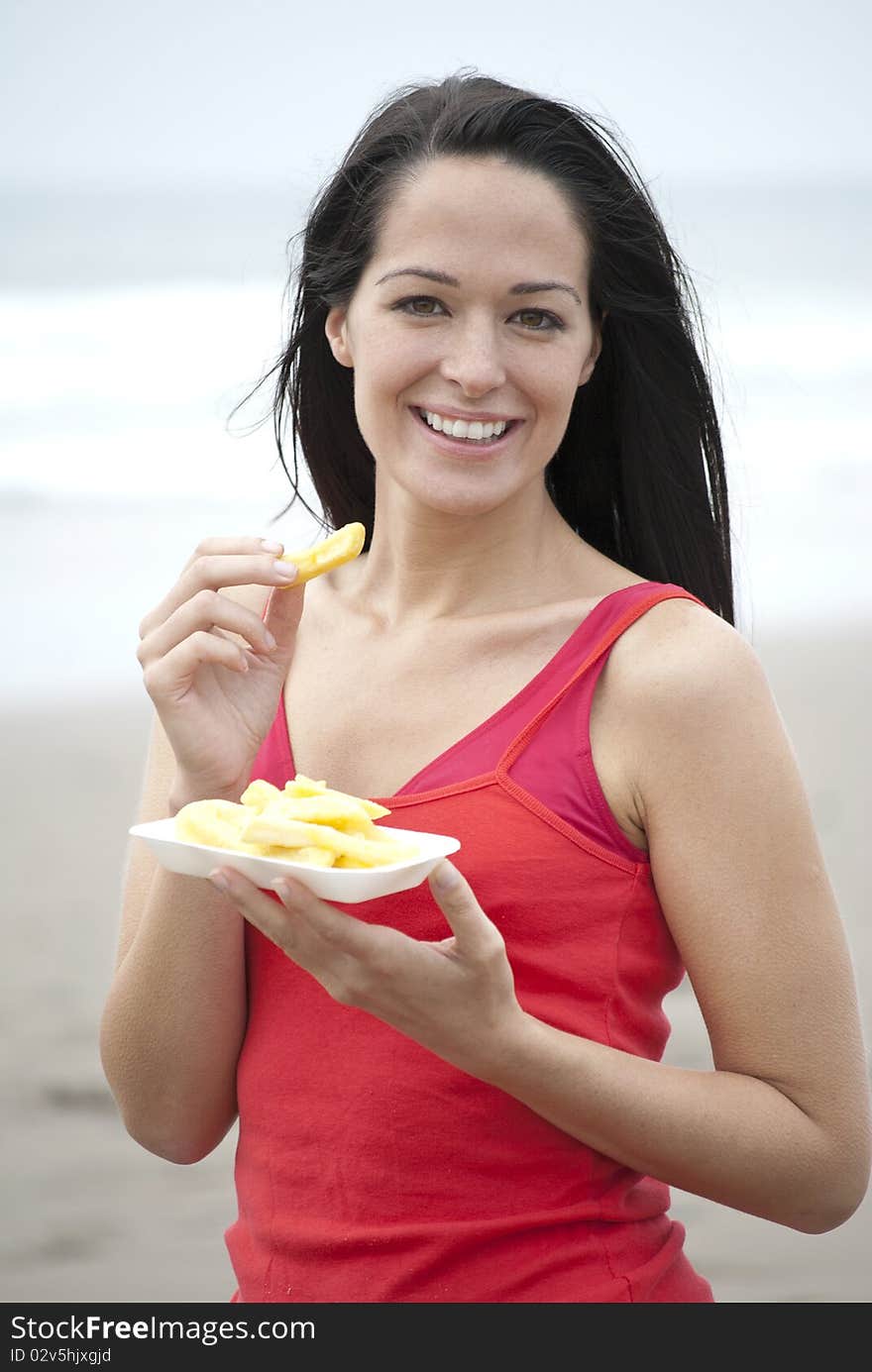 Woman eating chips at the beach