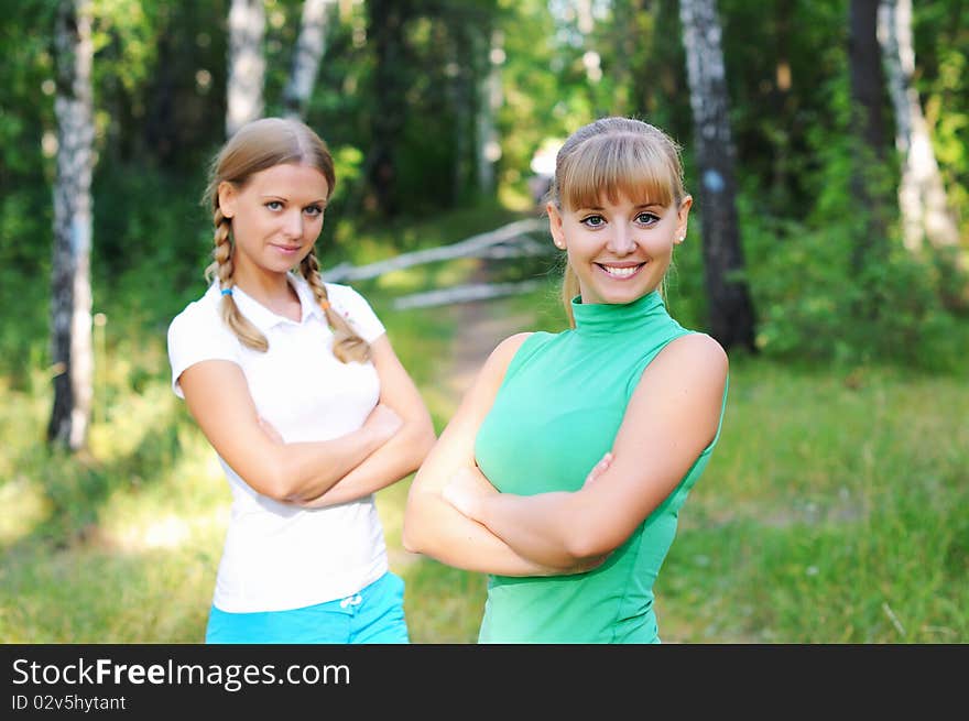 Two beautiful girls in summer forest