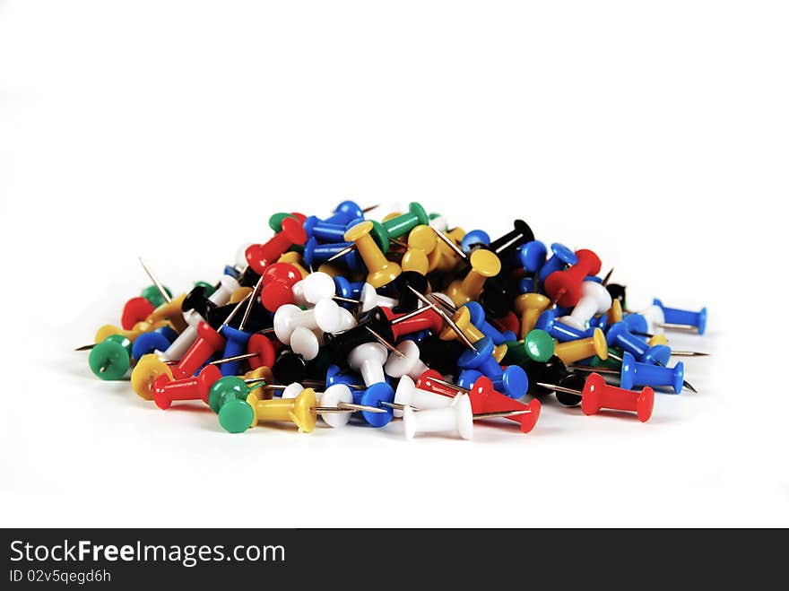 A pile of colourful thumbtacks isolated on a white background. A pile of colourful thumbtacks isolated on a white background