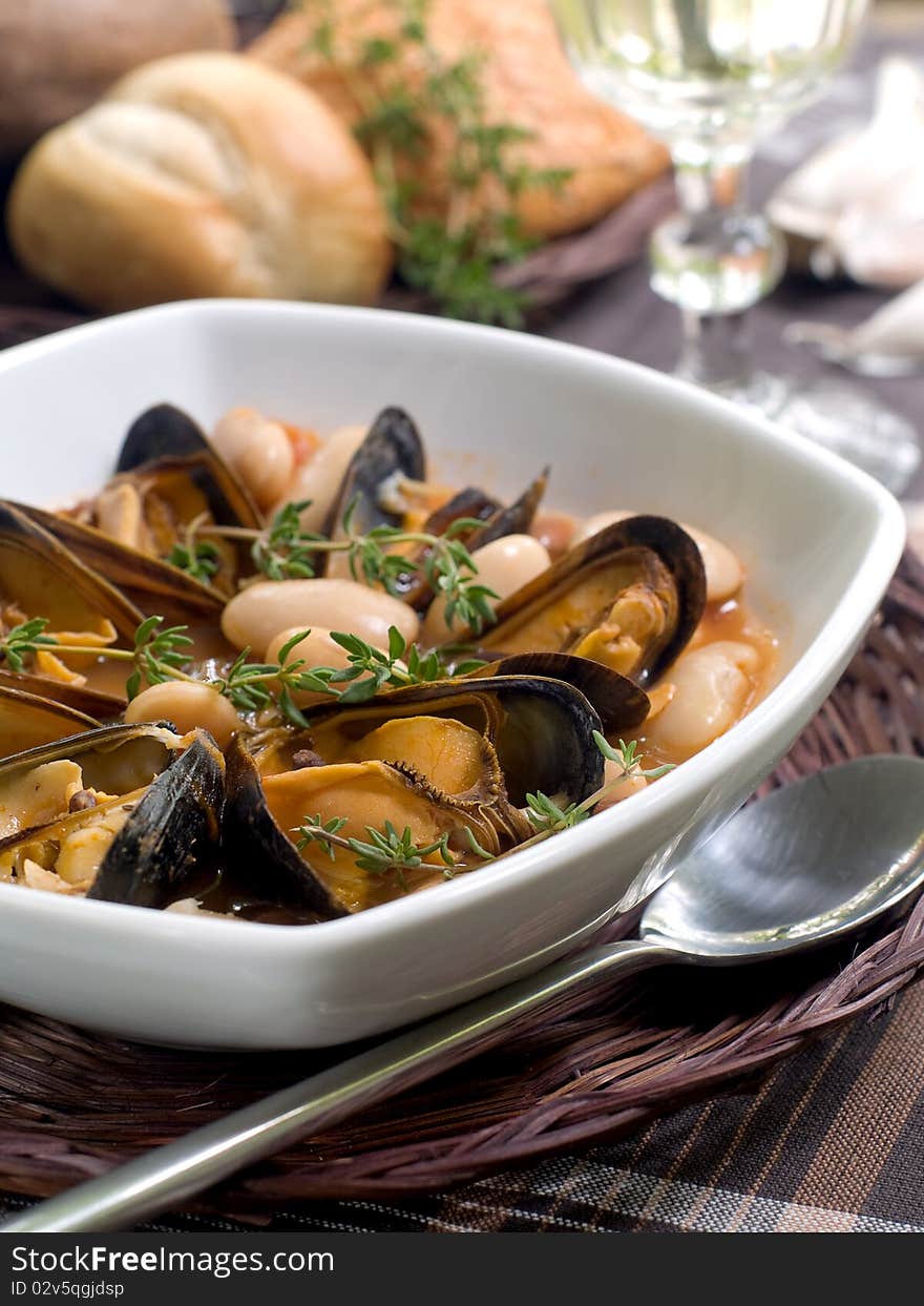 Mussel soup with bean and thyme on bowl