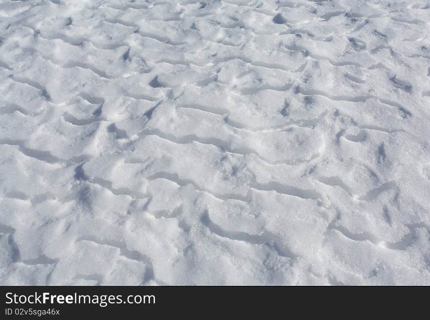 Wind blown snow drifts on frozen ice surface of a mountain lake. Wind blown snow drifts on frozen ice surface of a mountain lake