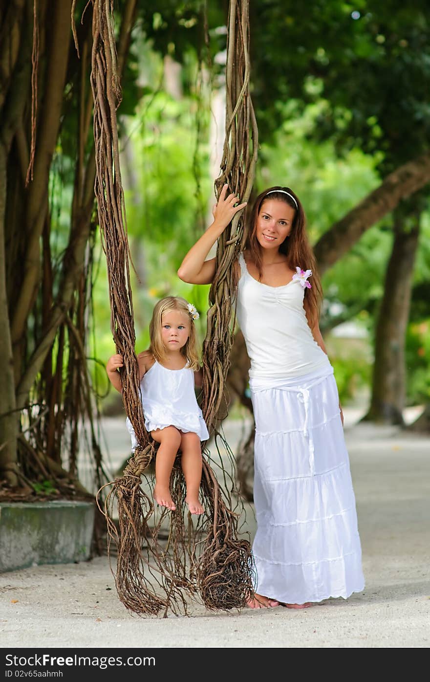 Young Mother And Her Daughter In Tropical Park