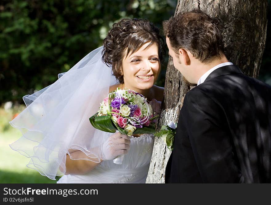 Bride and groom having fun in park