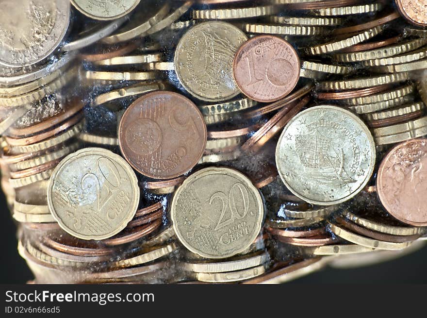 Shiny euro coins frozen in ice