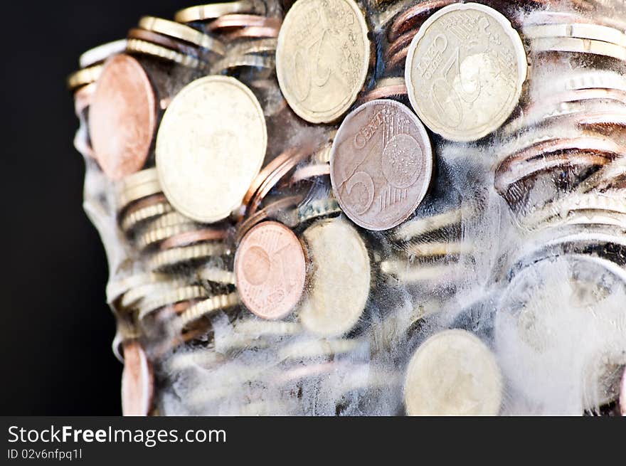 Shiny euro coins frozen in ice