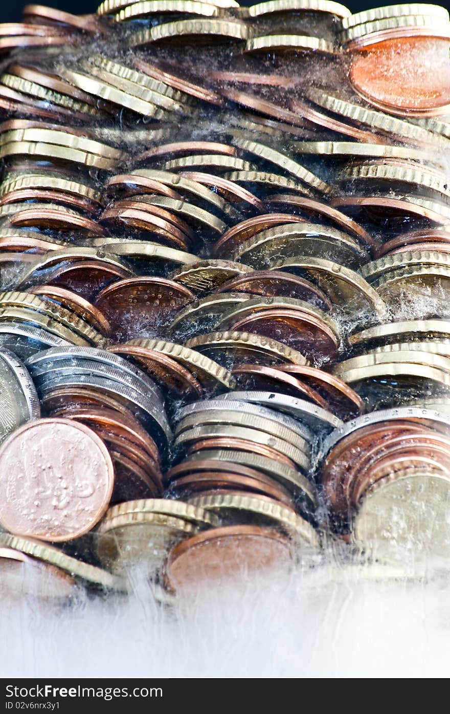 Shiny euro coins frozen in ice