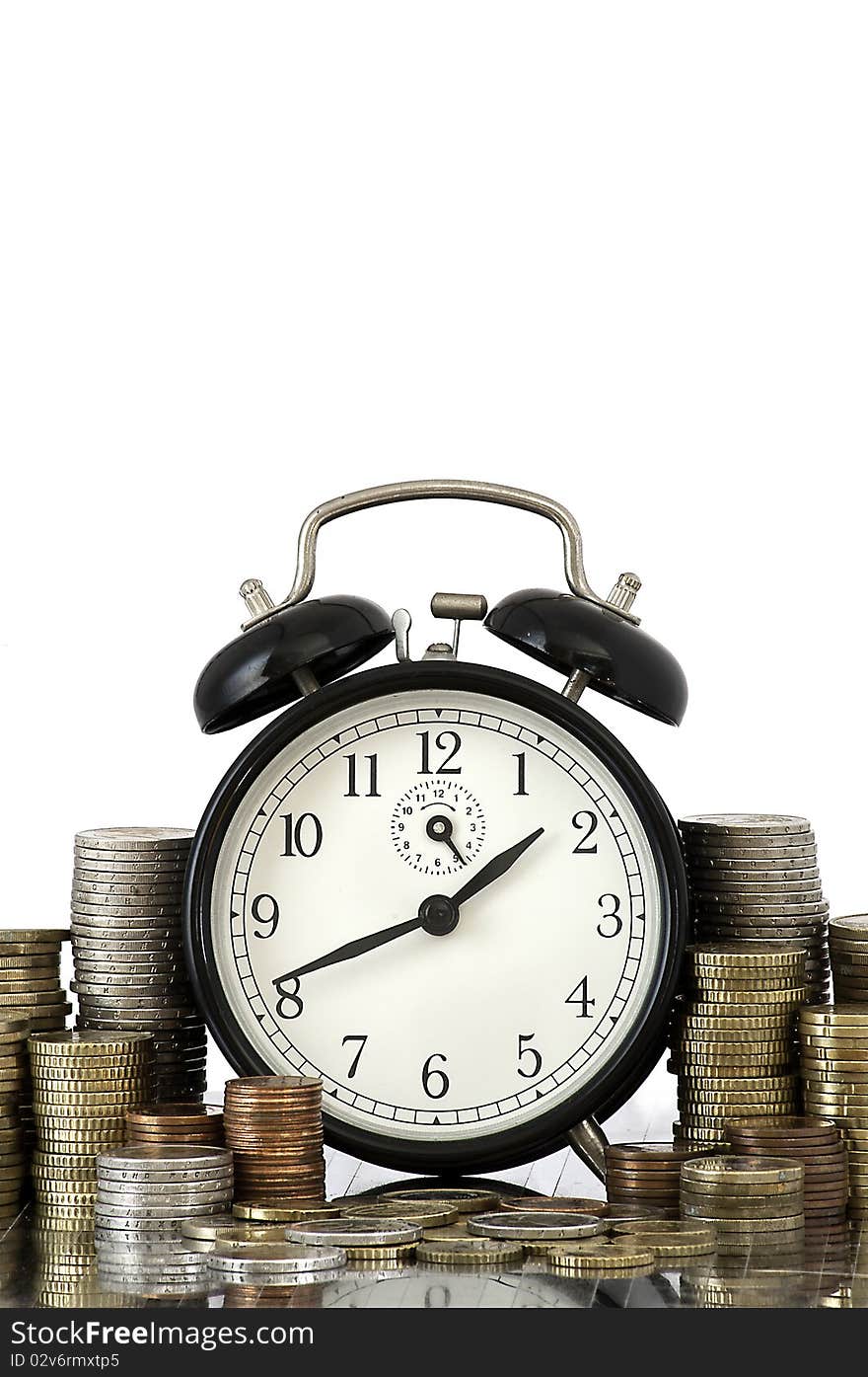 Alarm clock standing with coins on metal plate. Alarm clock standing with coins on metal plate