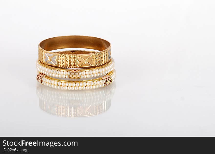 Beautiful golden pearl bangles isolated on white