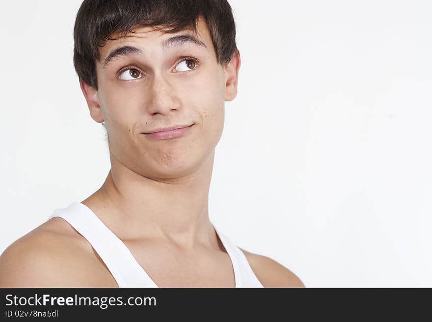 Closeup of a handsome young teenaged guy looking away in thought isolated on white