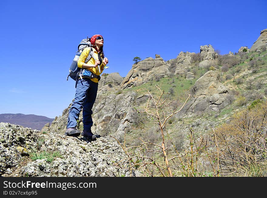 Girl tourist with a backpack on a background of mountains. Girl tourist with a backpack on a background of mountains