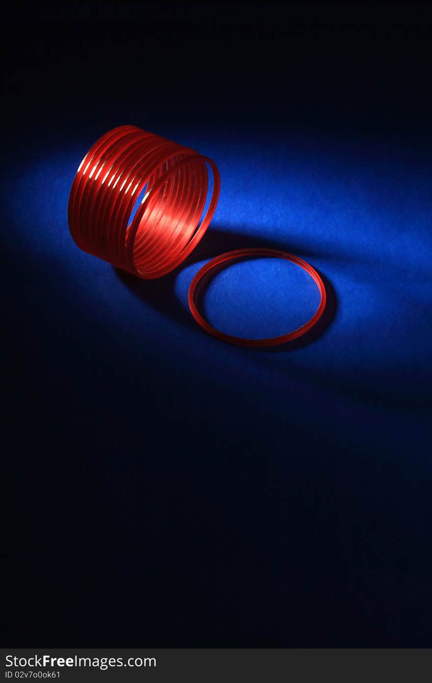 Abstract image of red bangles in dark blue background. Abstract image of red bangles in dark blue background