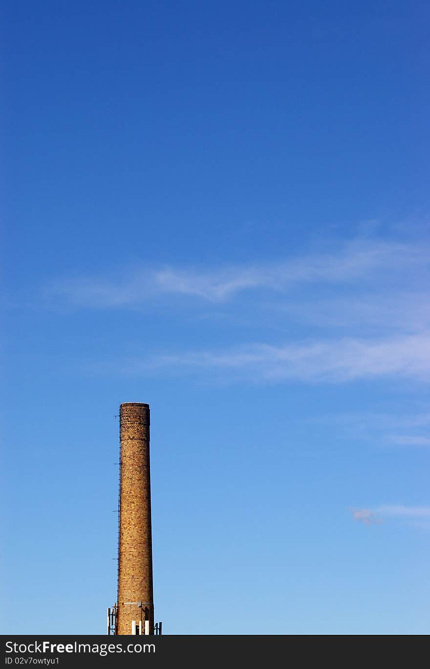 Old brick chimney against blue sky with clouds. Old brick chimney against blue sky with clouds