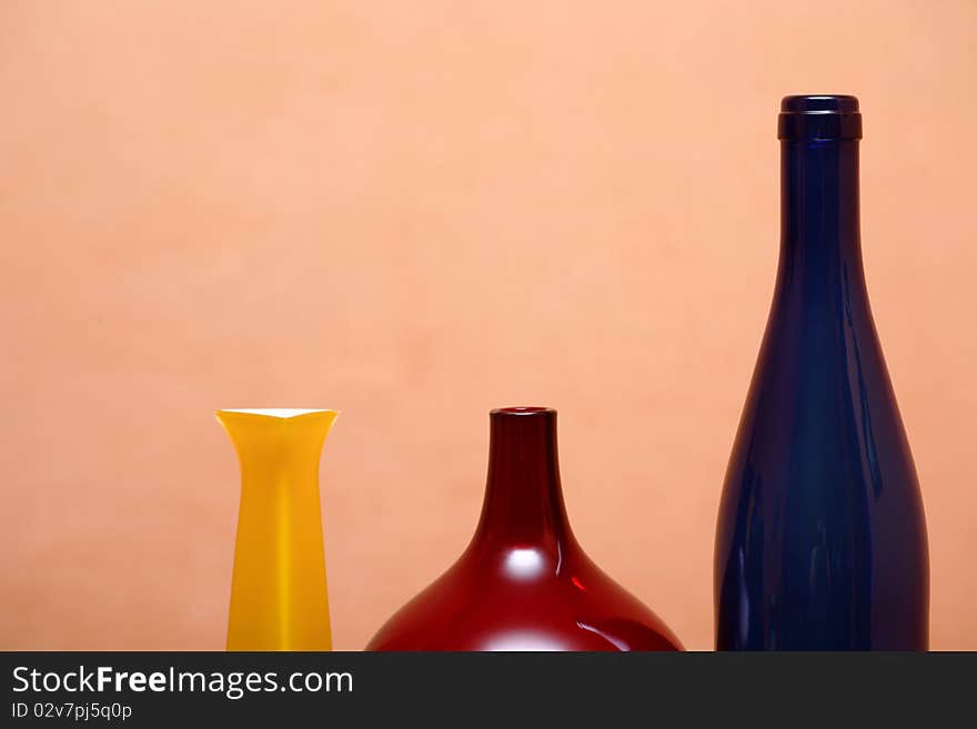 Three various glass motley vases isolated on pink background