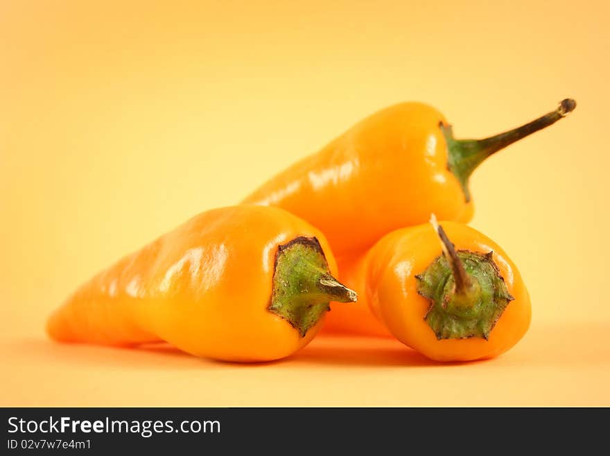 Hot yellow chili peppers on yellow background