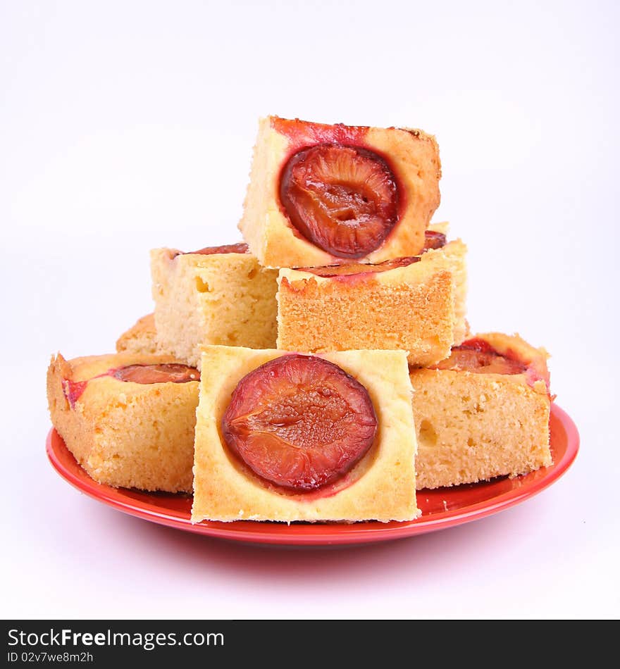 Plum Pie - several portions on a red plate on white background