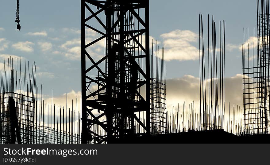 Silhouettes of builders and building structures on the background of a sunset. Silhouettes of builders and building structures on the background of a sunset