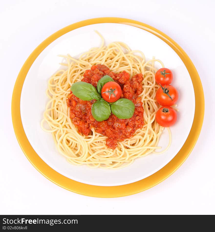 Spaghetti Bolognese on a plate decorated with fresh basil and cherry tomatoes on white background