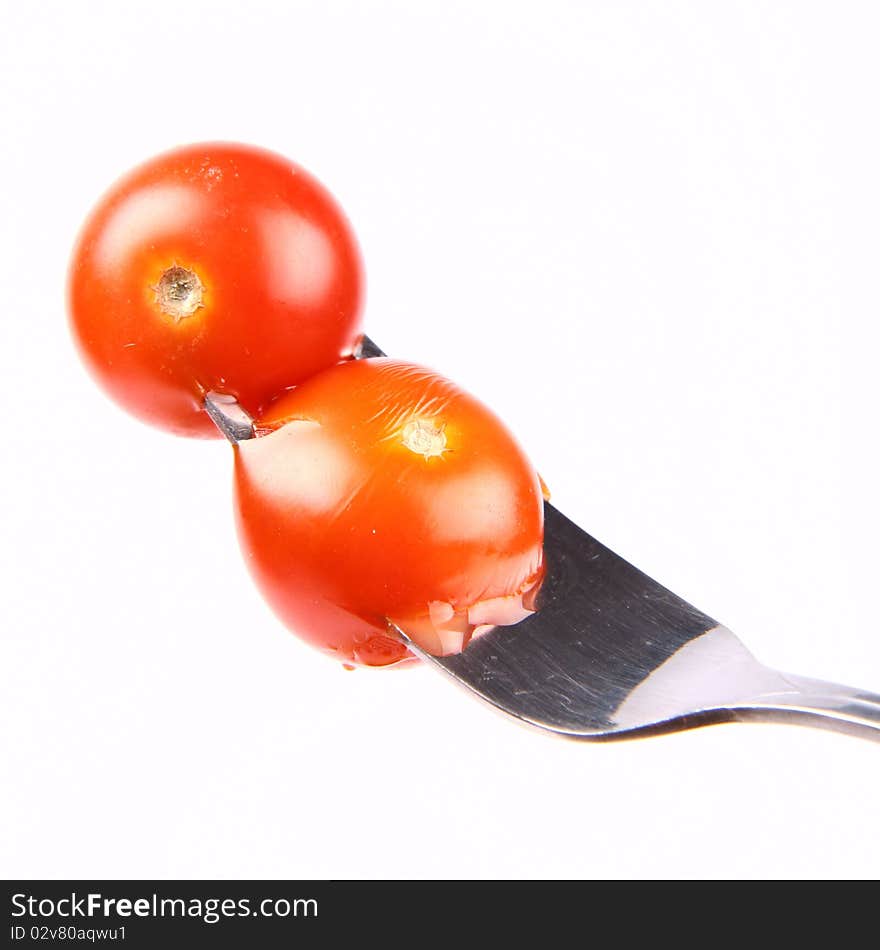 Cherry tomatoes on a fork on white background