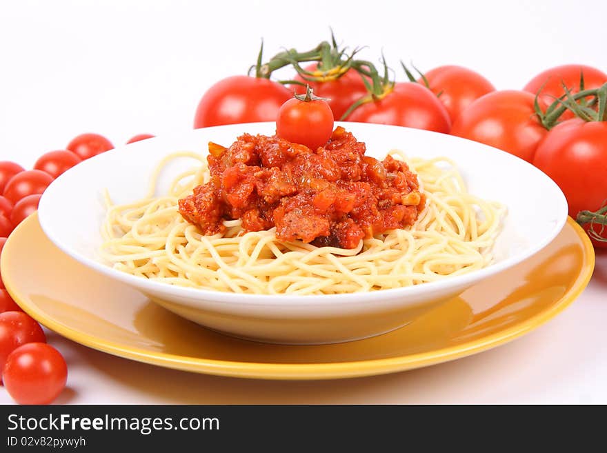 Spaghetti Bolognese on a plate surrounded with tomatoes and cherry tomatoes