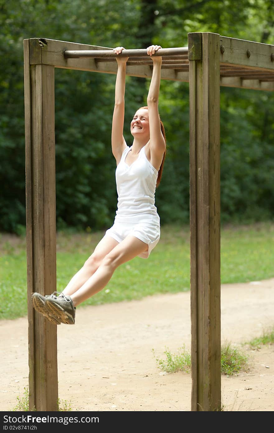 Young woamn doing physical exercise outdoors. Young woamn doing physical exercise outdoors