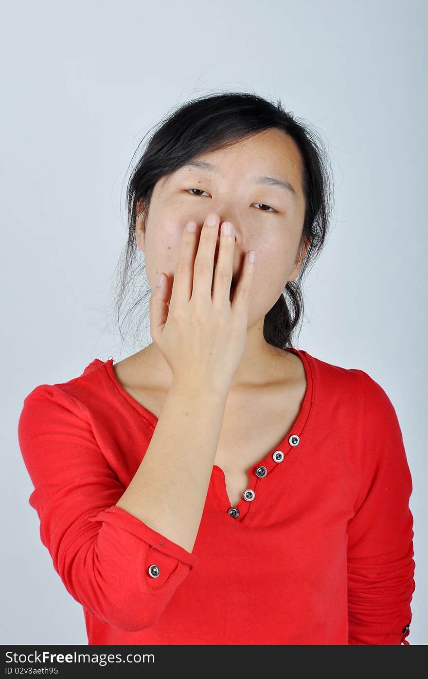 A Chinese girl is yawning，She held her hand blocking the mouth. A Chinese girl is yawning，She held her hand blocking the mouth