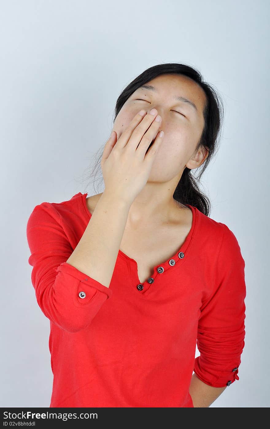 A Chinese girl is yawning，She held her hand blocking the mouth. A Chinese girl is yawning，She held her hand blocking the mouth