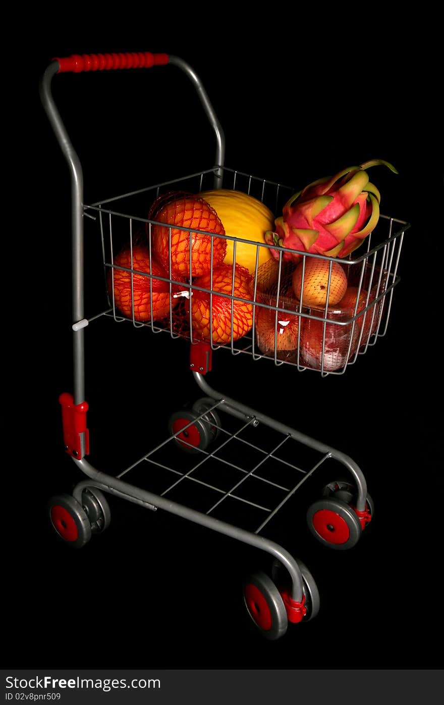 Shopping trolley full of fruit isolated on a black background