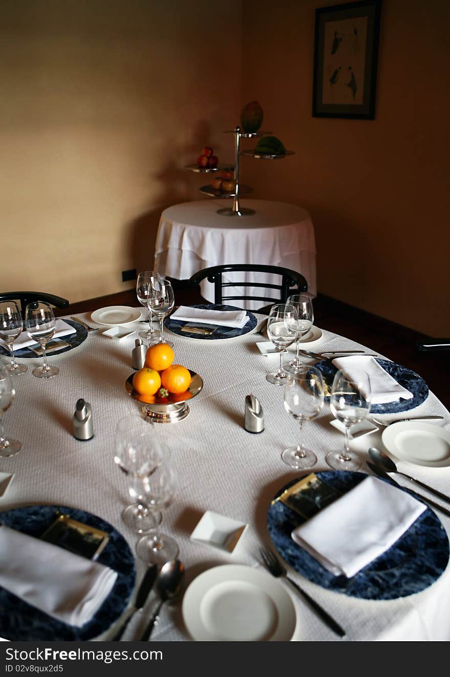 Decorative table place setting with silver cutlery glasses and oranges