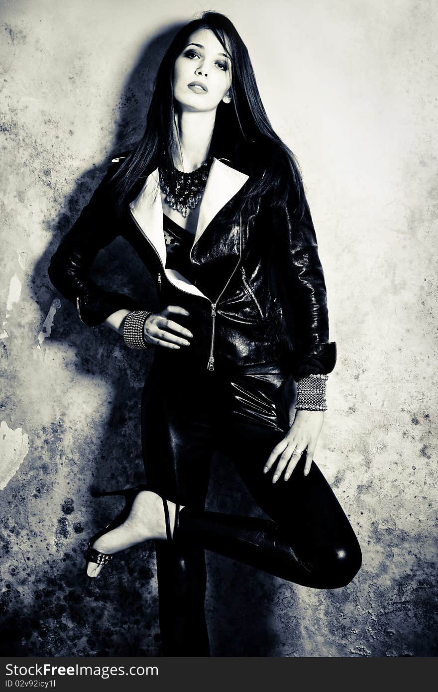 Young woman in black leather against dirty wall